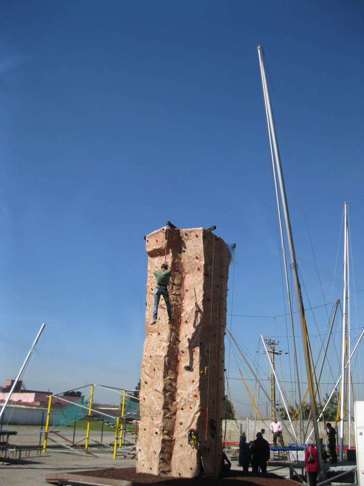 Le mur d'escalade mobile entouré des mâts des bungy trampolines