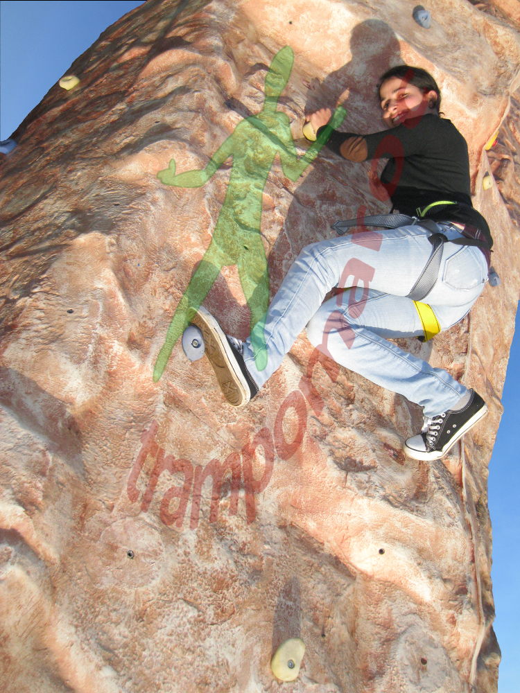 Une grimpeuse en pleine voie sur le mur d'escalade
